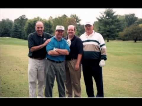 Priests taking a break from golf and smiling for a picture on the fairway